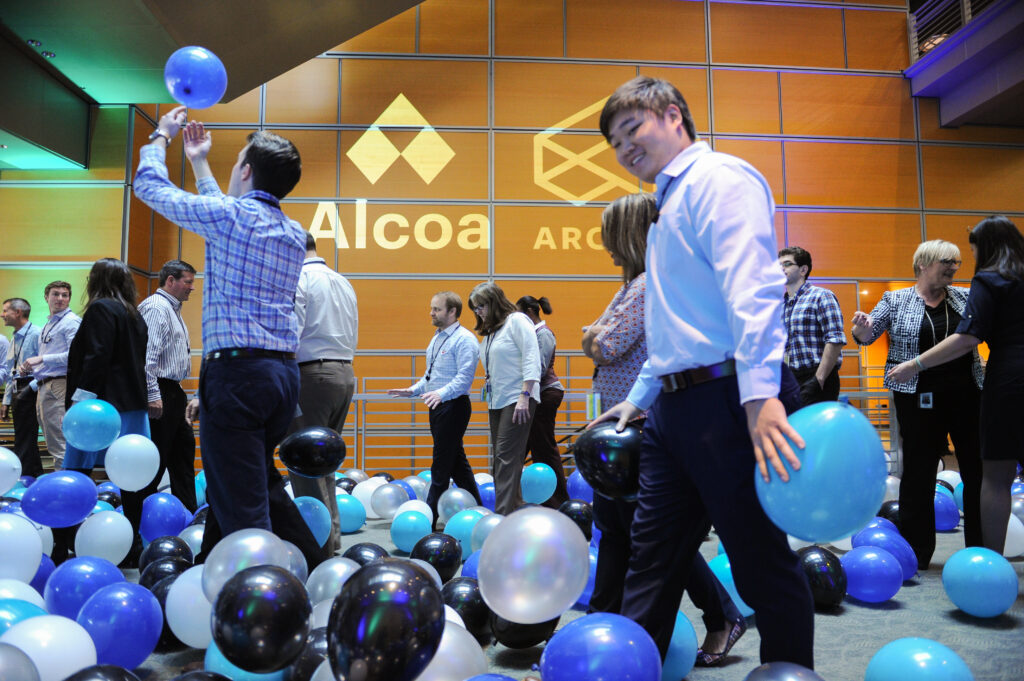 attendees play with branded balloons for Alcoa and Arconic event